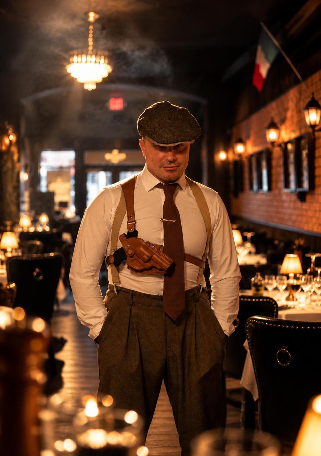 A waiter in a flat cap, white shirt, tie, suspenders and shoulder holster in the dining room